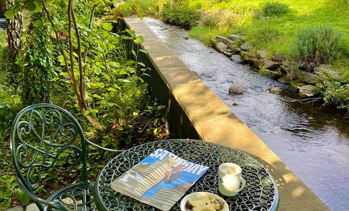 A table set amongst plants and flowers in the garden at Crafnant House